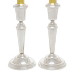 Zilveren kandelaars met gouden kaarsen