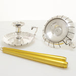 Silver chambersticks with golden candles next to the chambersticks